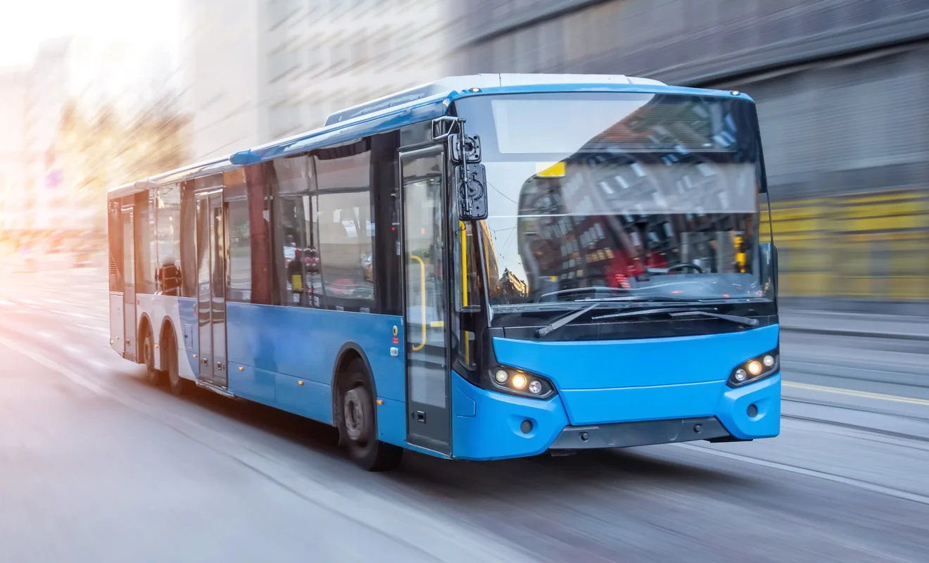 Blauer Linienbus fährt durch eine Innenstadt